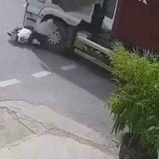 Cô gái đi xe máy lao thẳng vào gầm xe container