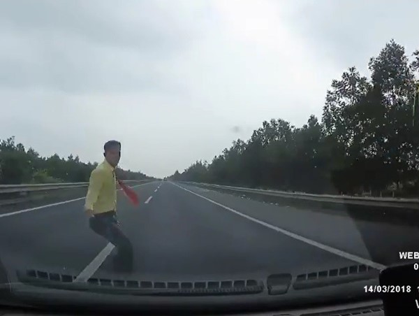 Người đi bộ liều mình băng qua đường cao tốc