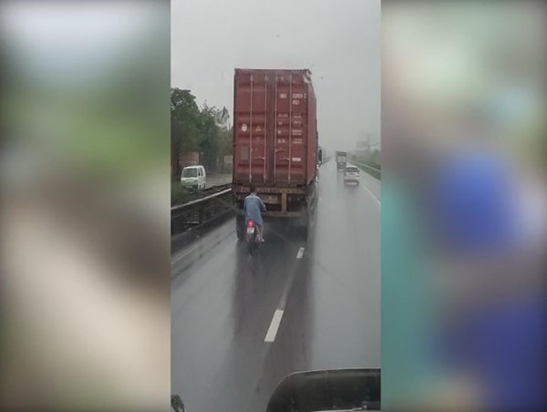 Clip: Khiếp vía nam thanh niên đi xe máy bám đuôi xe container trong làn ô tô để tránh mưa 