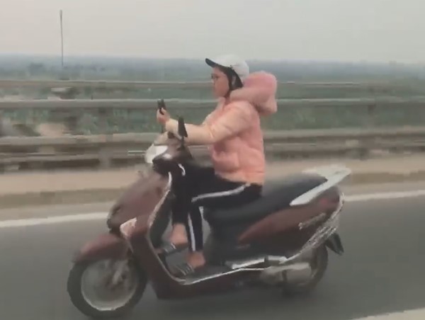 'Đứng tim' cảnh người phụ nữ đi xe máy video call trên cầu Nhật Tân 