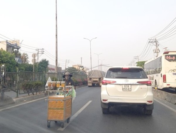 Hàng rong bất chấp hiểm nguy lấn chiếm lòng đường quốc lộ 1A