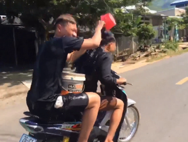 Hai thanh niên vừa chạy xe máy vừa gội đầu bị xử phạt 1,5 triệu đồng