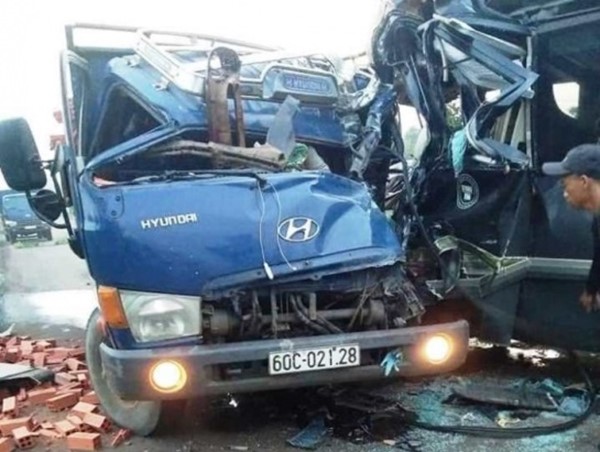 Xe tải chở gạch đối đầu xe khách, 2 tài xế kẹt cứng trong cabin