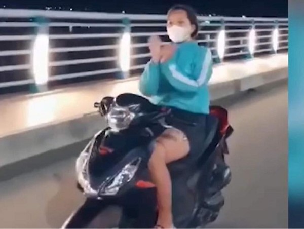 Cô gái vừa lái xe máy vừa thả tay ''múa quạt''