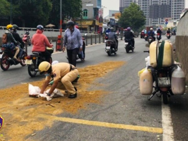Cảnh sát giao thông lấp dầu nhớt đảm bảo an toàn giao thông cho người đi đường
