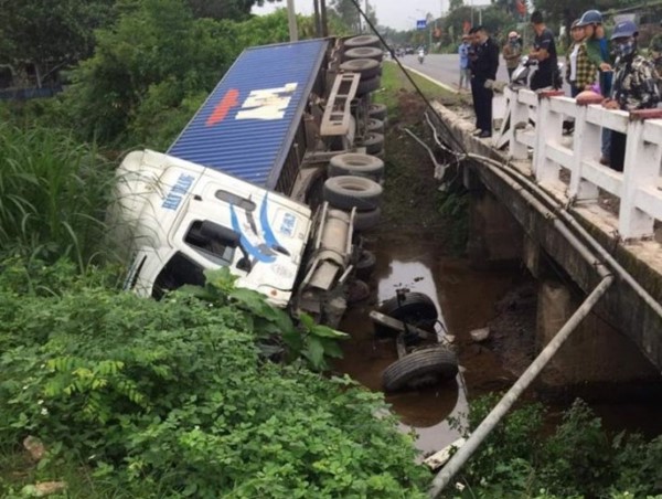 Xe đầu kéo tự tông vào thành cầu rồi rơi xuống nước, tài xế bị thương