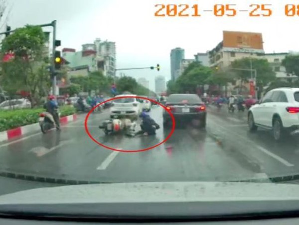 [Clip] Đi nhanh trời mưa, người đi xe máy phanh gấp ngã cạnh gầm ôtô