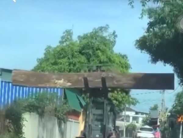 Nín thở khi đi qua chiếc xe đang nâng khúc gỗ khổng lồ