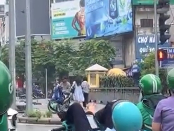 Tài xế xe ôm công nghệ nằm vắt vẻo chờ đèn đỏ