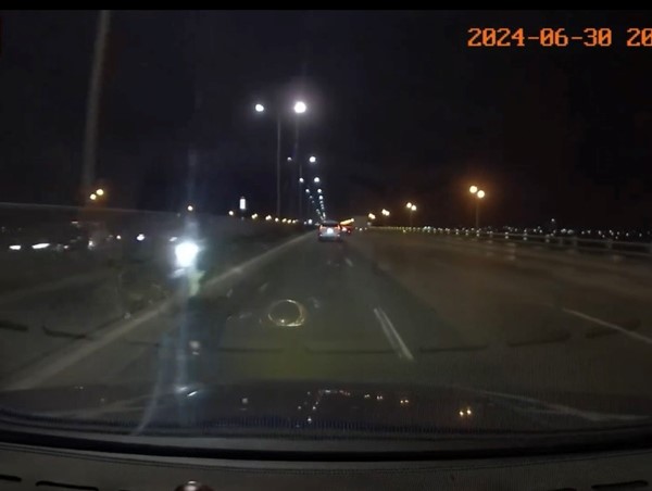 Xe máy bật đèn pha đi ngược chiều bên làn đường ô tô