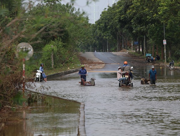 Đại lộ Thăng Long vẫn ngập, người dân phải thuê xe bò “cõng” xe máy