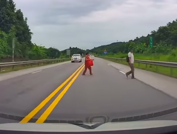 Hai người đi bộ sang đường trên cao tốc Nội Bài - Lào Cai 