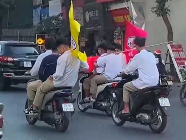 Nhóm thanh thiếu niên không đội mũ bảo hiểm, kẹp ba điều khiển xe máy dàn hàng ngang trên đường