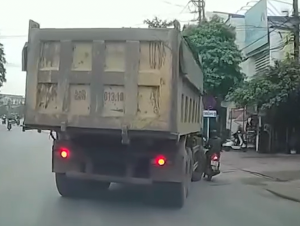 Tài xế xe máy suýt gặp nạn dưới bánh xe tải