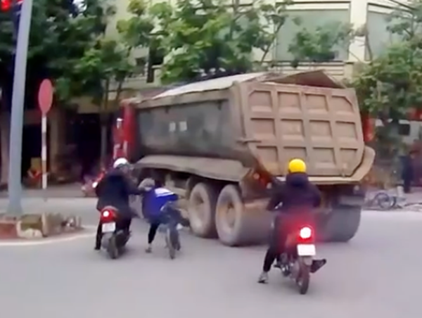 Người đàn ông nhanh trí kéo em bé đi xe đạp khỏi điểm mù xe tải