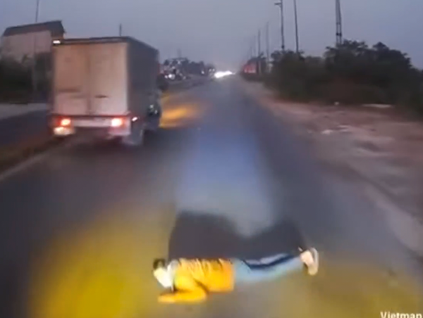 Người đàn ông nằm ra đường đúng lúc xe tải đi tới