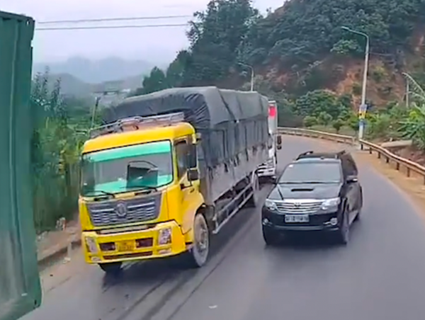 Ô tô biển xanh suýt va chạm với xe đầu kéo vì vượt ẩu