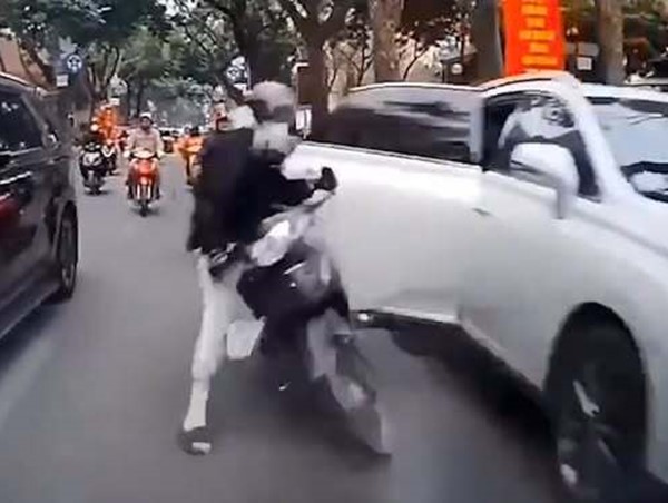 Mở cửa ô tô bất cẩn khiến tài xế xe máy ngã văng ra đường