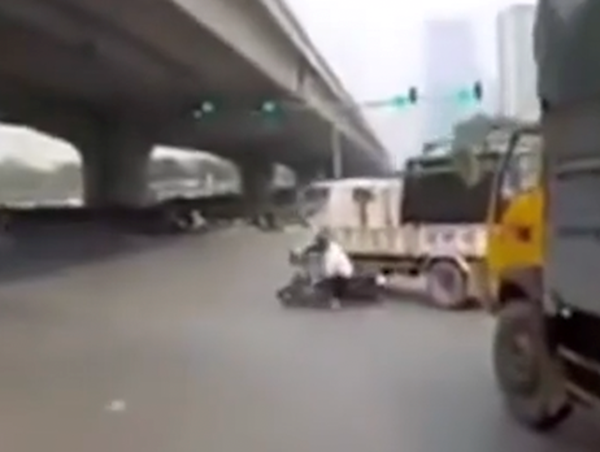 Luồn lách sai làn để vượt, người đi xe máy trượt ngã vào ô tô tải