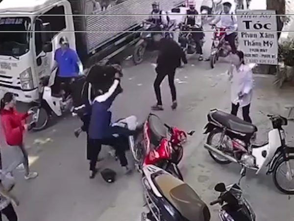 Nhóm học sinh cầm mũ bảo hiểm lao vào đánh tới tấp nam sinh đi xe máy