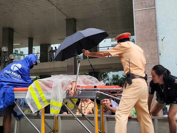 CSGT Hà Nội dùng xe chuyên dụng vượt đường ngập chở bệnh nhân đi cấp cứu 