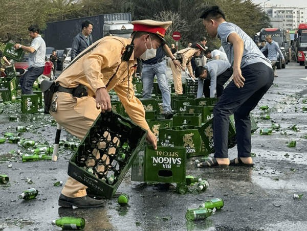 Cảnh sát giao thông và người dân giúp thu dọn hàng trăm thùng bia tràn xuống cao tốc