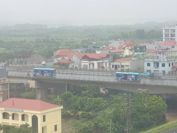 Hai xe buýt chắn gió cho người dân đi trên cầu Nhật Tân khi bão to