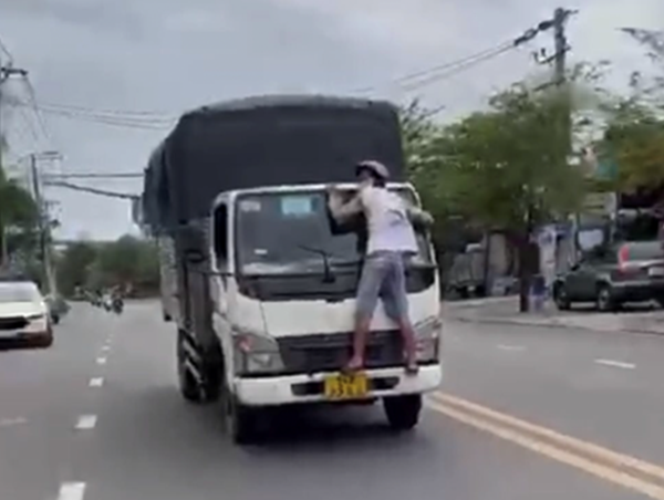 Tài xế xe tải phóng vun vút dù có người đu bám đầu xe