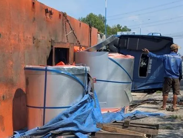 Xe đầu kéo chở hàng chục tấn tôn bất ngờ lật nhào giữa phố