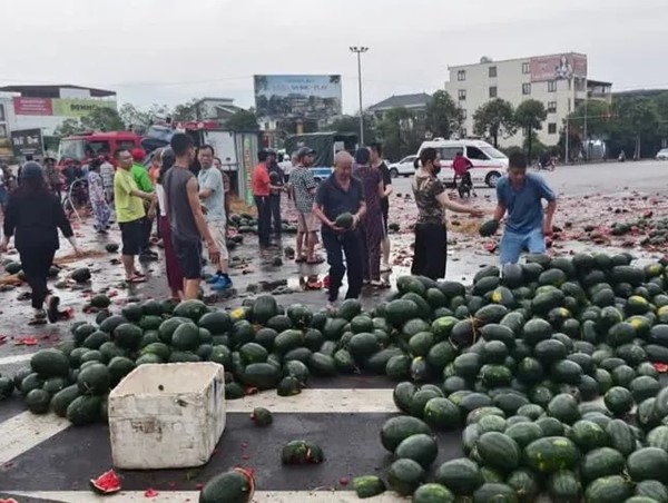 Người dân hỗ trợ xe tải chở hàng tấn dưa hấu bị lật