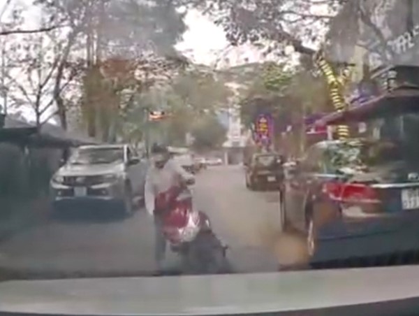 Sử dụng điện thoại khi đi xe máy, cô gái ngã trước đầu ô tô
