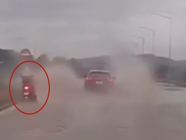 Ô tô lao nhanh trên đường ngập, té nước xối xả vào người đi xe máy