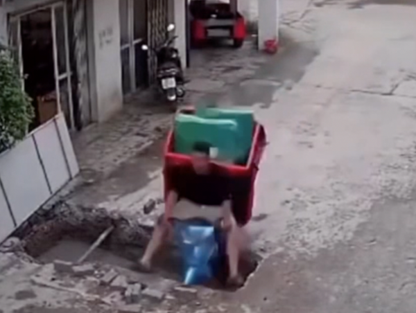 Mải nhìn điện thoại, tài xế lái xe máy lao xuống hố công trình
