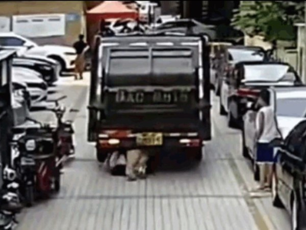 [Clip]: Mải lướt điện thoại, người phụ nữ bị xe chở rác cuốn vào gầm