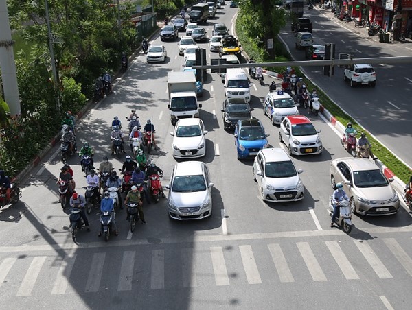 Bất chấp nguy hiểm, người dân núp bóng râm chờ đèn đỏ