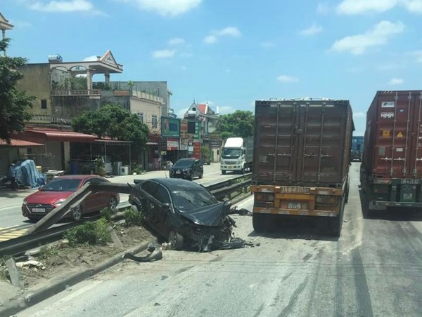 Vượt ẩu trước đầu container, xe ô tô con bị húc văng lên dải phân cách