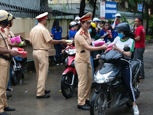 Cảnh sát giao thông “xuống đường” tặng nước, áo mưa cho sĩ tử TP.HCM