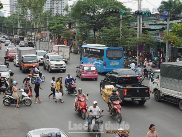 Thờ ơ với cây cầu vượt, người đi bộ luồn lách băng qua đường