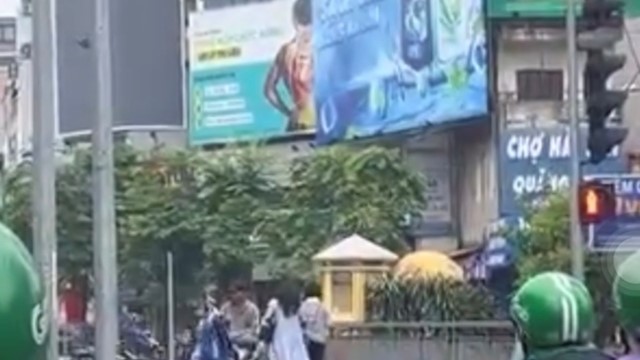 Tài xế xe ôm công nghệ nằm vắt vẻo chờ đèn đỏ