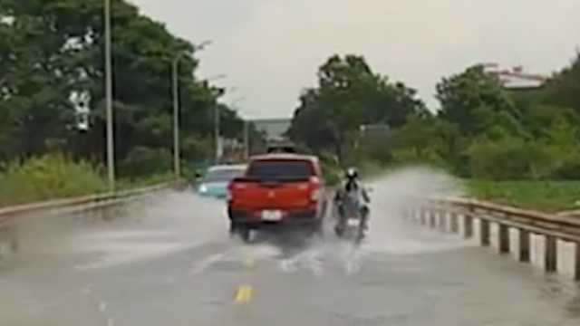 Xe bán tải tạt nước, chèn ép người đi xe máy giữa đường ngập