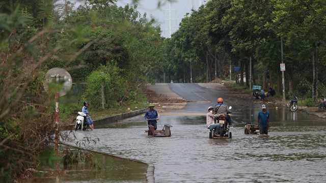 Đại lộ Thăng Long vẫn ngập, người dân phải thuê xe bò “cõng” xe máy