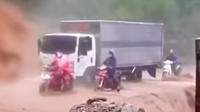 Cảm động tài xế dùng xe tải cho xe máy đi qua đoạn sạt lở, nước chảy cuồn cuộn