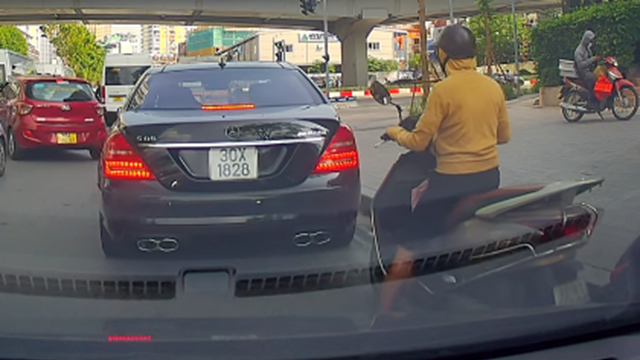Dừng chờ đèn tín hiệu, xe ô tô đi lùi suýt tông trúng người đi xe máy
