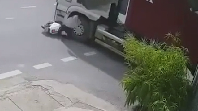 Cô gái đi xe máy lao thẳng vào gầm xe container