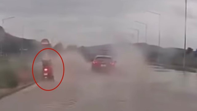 Ô tô lao nhanh trên đường ngập, té nước xối xả vào người đi xe máy