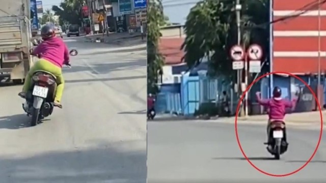 Người phụ nữ đi xe máy đánh võng, buông 2 tay trên đường phố