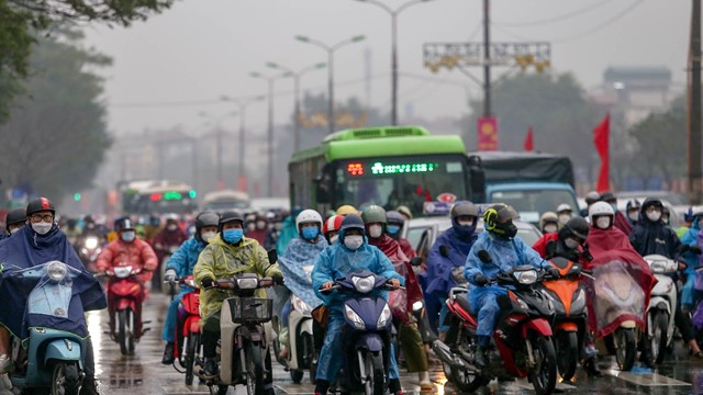 Người dân đội mưa, ùn ùn trở lại Hà Nội sau Tết