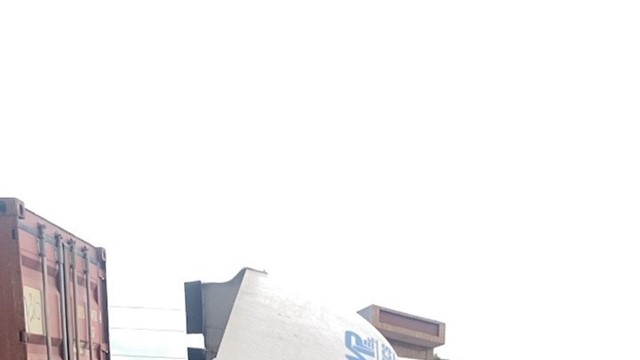 Xe container đâm vào lan can cầu vượt và mắc lại thành cầu