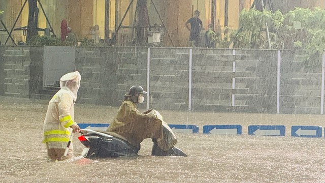 Hà Nội: Lực lượng chức năng dầm mưa hỗ trợ người dân đi lại