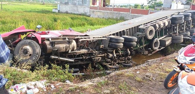 Xe container lat nghieng duoi ruong lua, tai xe thoat nan - Hinh anh 1